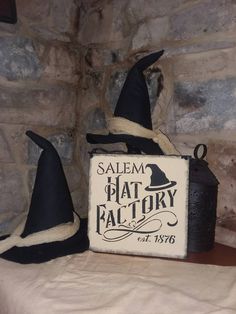 two witches hats sitting on top of a table next to a sign that says salem hat factory