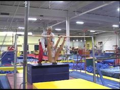 two people doing acrobatic tricks in an indoor trampoline gym with blue and yellow mats