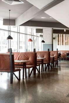 an empty restaurant with leather seats and tables