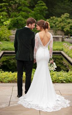 a bride and groom looking at each other while standing in front of an ornamental garden