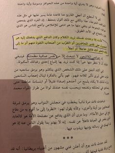 an open book with arabic writing on the page and yellow marker in it's center