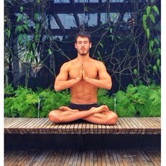 a man is sitting in the middle of a yoga pose