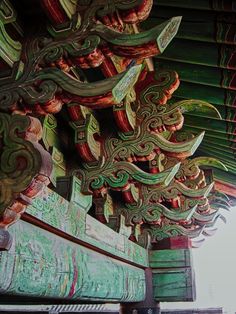 an intricately decorated roof in the middle of a chinese style building with blue and green paint on it