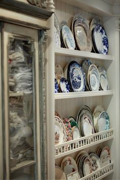 an old china cabinet with blue and white plates on it