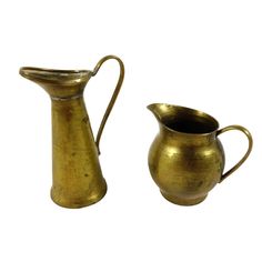 two brass pitchers, one with a handle and the other without