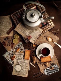 a tea pot sitting on top of a table next to some books and lemon slices