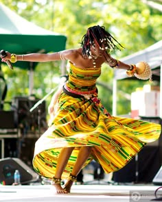 a woman in a colorful dress dancing on stage