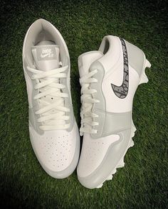 a pair of white nike shoes sitting on top of green grass