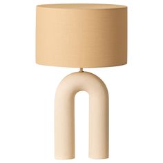 a table lamp with an oval shaped base and a beige drum light shade on top