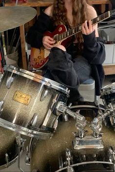 a woman sitting on top of a drum kit