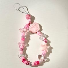 a pink and white beaded necklace on a table