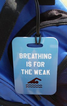 a blue backpack with a tag that says breathing is for the weak on it's front pocket