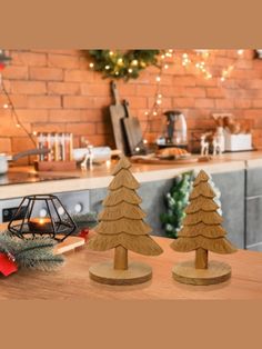 two wooden christmas trees sitting on top of a table next to a kitchen countertop