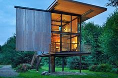 a tall metal structure sitting on top of a lush green field next to trees at night