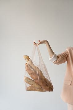 a woman holding a clear bag full of bread