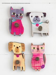 three wooden magnets depicting cats and dogs on a white background, each with a different color scheme