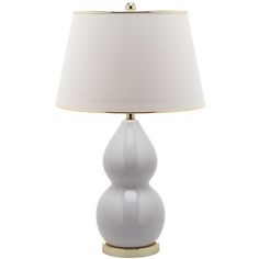 a white table lamp with a gold base and a light shade on the top of it