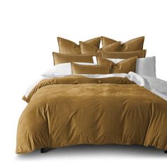 a bed covered in brown and white pillows next to a pillow case with several pillows on it