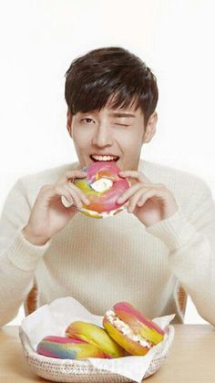 a man sitting at a table eating a doughnut