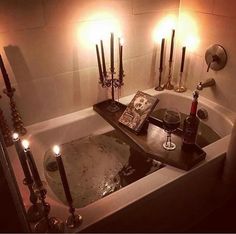 a bathtub with candles and wine in it