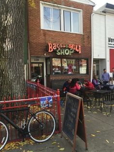 people sitting at tables in front of a store