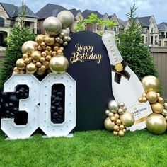 a birthday sign with balloons and decorations in front of it