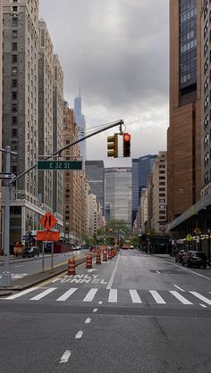 an empty city street with traffic lights and construction cones