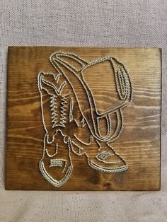 a wooden plaque with a drawing of a baseball glove on it