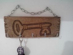 a key chain hanging from a wooden sign with a corkscrew design on it