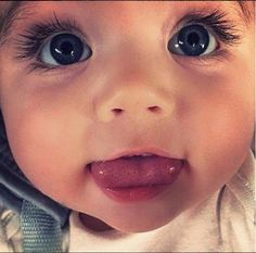 a close up of a baby with big blue eyes