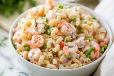 a white bowl filled with pasta salad on top of a table