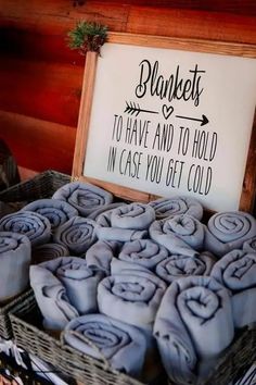 a basket filled with blue towels next to a sign that says blankets to have and to hold in case you get cold