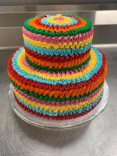 a multicolored cake is sitting on a plate