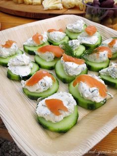 cucumbers with cream cheese and salmon on them are arranged on a platter