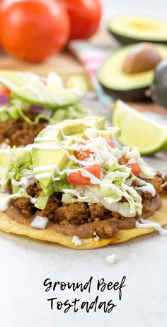 ground beef tostadas with avocado, tomatoes and lettuce on the side