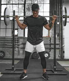 a man in black shirt and white shorts lifting a barbell