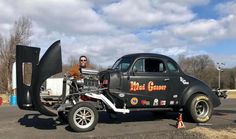 a man standing next to an old car with stickers on it