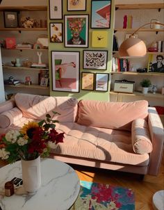 a living room filled with furniture and pictures on the wall