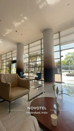 a living room filled with furniture next to large windows and tall columns on the wall