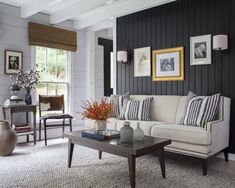 a living room filled with furniture and pictures on the wall next to a coffee table