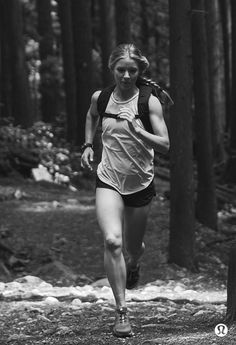 black and white photograph of a woman running in the woods