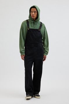 Baggy fit overalls by the essential BDG denim label. Classic bib front overalls with adjustable shoulder straps and utility pockets. Urban Outfitters exclusive. Features BDG Nitro baggy overall Workwear bib front overalls Adjustable shoulder straps Pouch front pocket Utility pockets UO exclusive Content + Care 100% Cotton Machine wash Imported Size + Fit Model in Charcoal is 6’2" and wearing size 32 Measurements taken from size 32 Length: 65" Rise: 13.5" Inseam: 29" Leg opening: 11" | BDG Nitro Cheap Men's Overalls For Streetwear, Male Overalls, Men’s Overalls, Men’s Black Overalls, Non-stretch Dark Wash Cotton Overalls, Denim Label, Men Bodies, Black Overalls, Utility Pockets