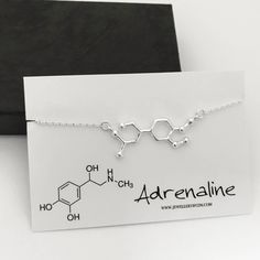 Pictures are enlarged to show details of the item. Please refer to original size and measurements in the following description  Sterling silver adrenaline necklace. Beautiful necklace representing the molecular structure of adrenaline.  The perfect gift for any science enthusiast or adrenaline junkie. Necklace comes in a gift box with a message card. Details: - Material metal: sterling silver - Adrenaline pendant measures 14x33mm PERSONALIZATION: Add a necklace chain extender: https://etsy.me/2y Adrenaline Molecule, Chemistry Necklace, Chemistry Jewelry, Molecule Necklace, Science Jewelry, Molecular Structure, Chain Extenders, Jewellery Gift, Message Card