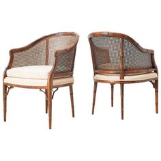 a pair of rattan chairs with white cushions