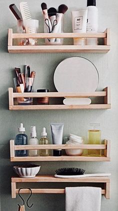 three wooden shelves filled with cosmetics and personal care items on top of eachother