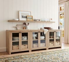 a wooden cabinet with glass doors and baskets on top