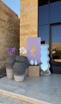 two vases with flowers are sitting on the steps