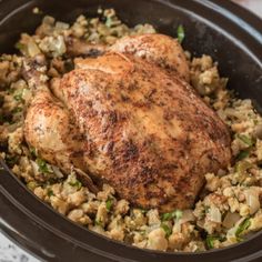 a close up of a chicken and rice dish in a crock pot on a table