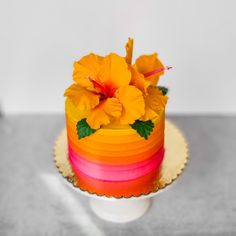 a multi - colored cake with flowers on top