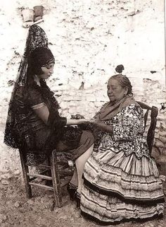 an old photo of two women sitting in chairs